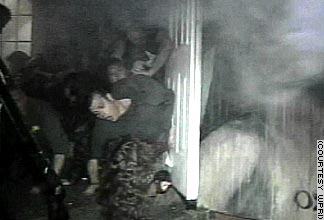 People jammed at the door, trying to get out. Note the black smoke over their heads.